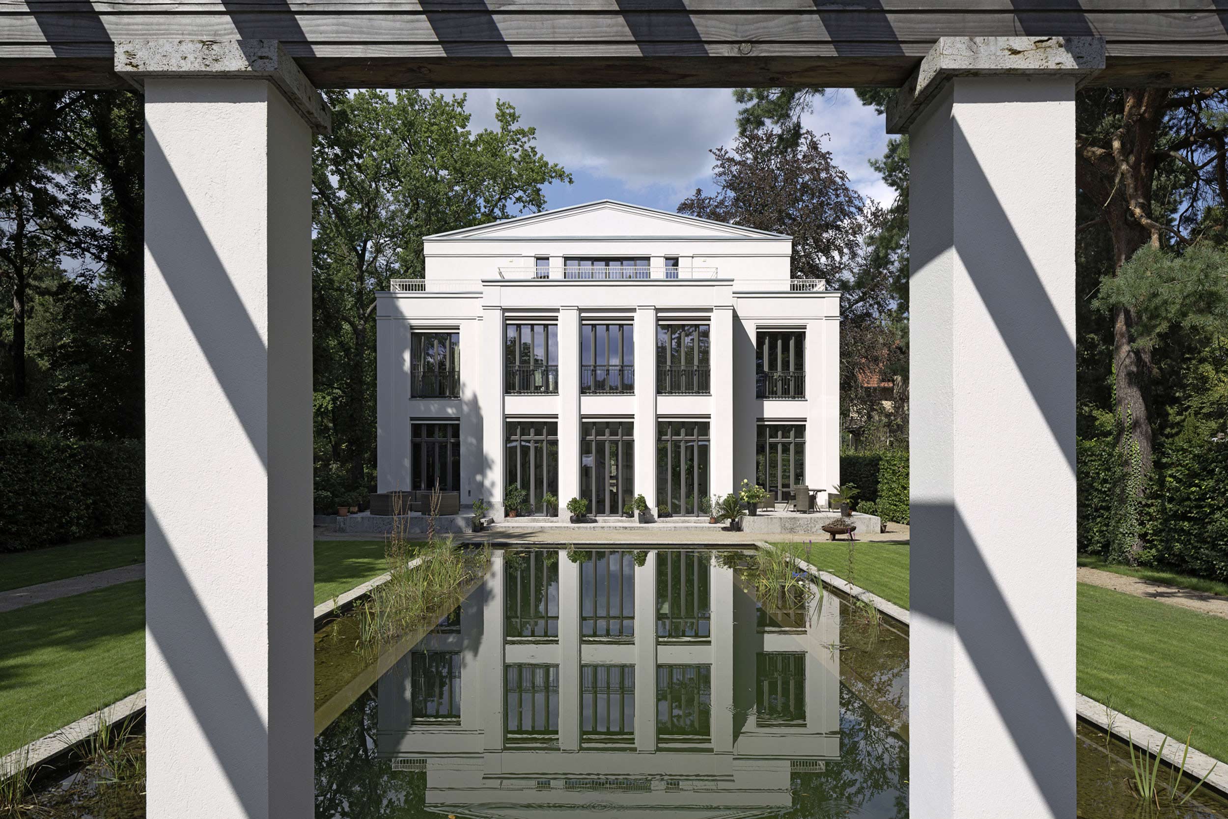 Neubau einer Villa im neoklassizistischen Stil - Klassisch profilierte Atelierfenster eröffnen einen wunderbaren Ausblick auf Gartenanlage und Teich