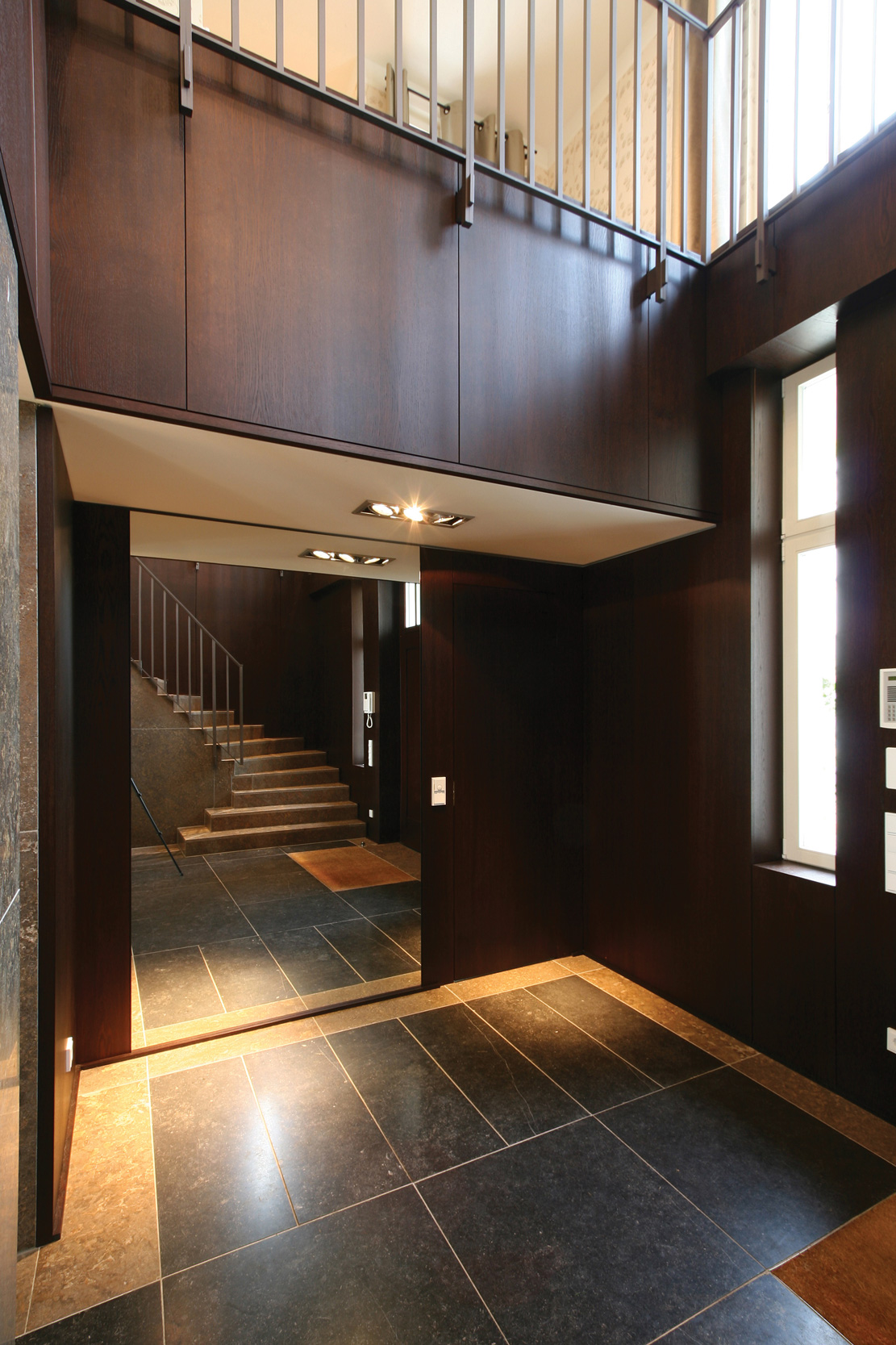 Neubau einer Villa in klassisch-traditioneller Architektursprache - Die Garderobennische mit in die Holzverkleidung eingebaute Spiegelwand
